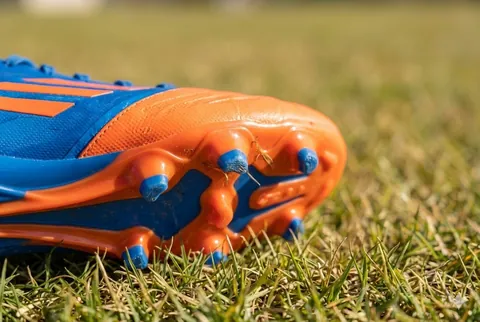 picture of a firm ground soccer cleat on grass