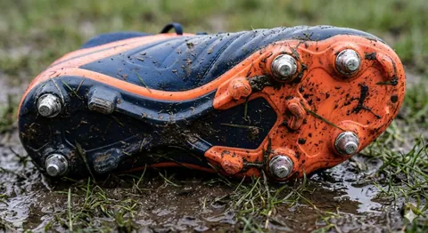 a dirty soccer cleat in grass and mud, shoring under the cleat