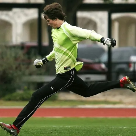 goalkeeper kicking a soccer ball on grass field